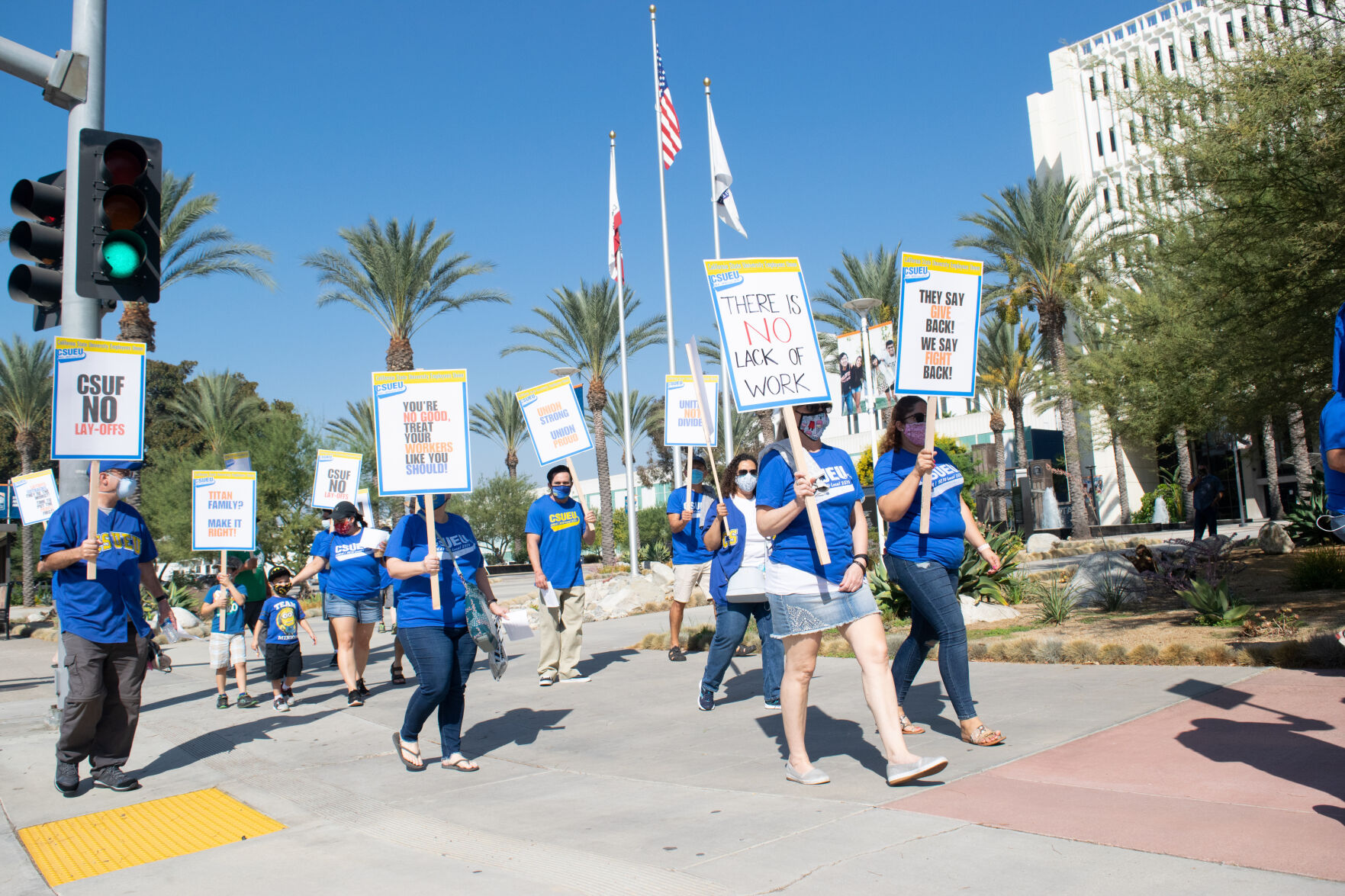 Supporters of the CSUF faculty and staff were laid off protest on campus holding signs on Saturday. (Natalie Solano / Daily Titan)